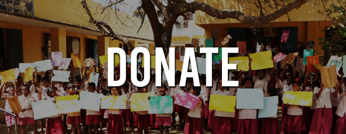 Children holding colorful sheets under a large donate banner